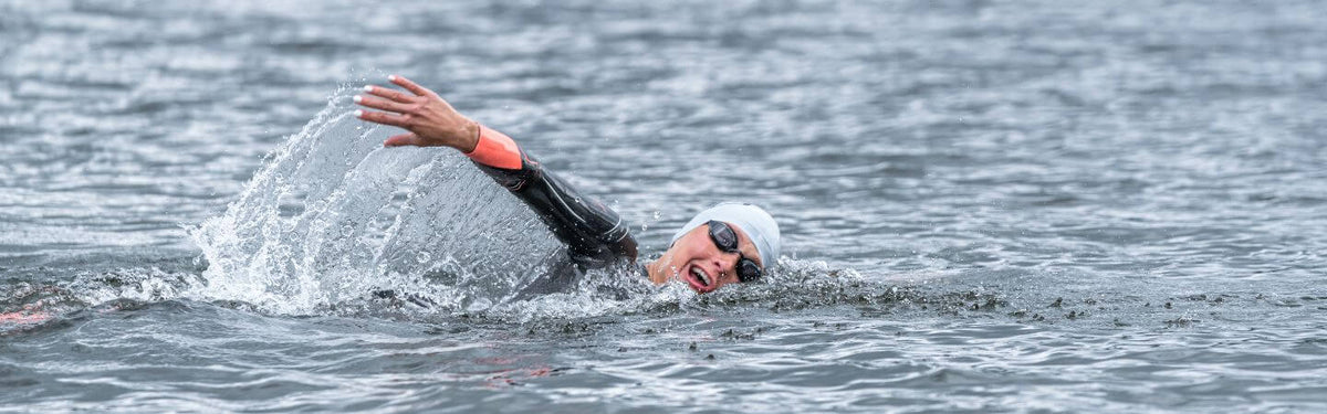 Rachel Klamer nage en eau libre avec une combinaison néoprène, des lunettes de natation et un bonnet de bain