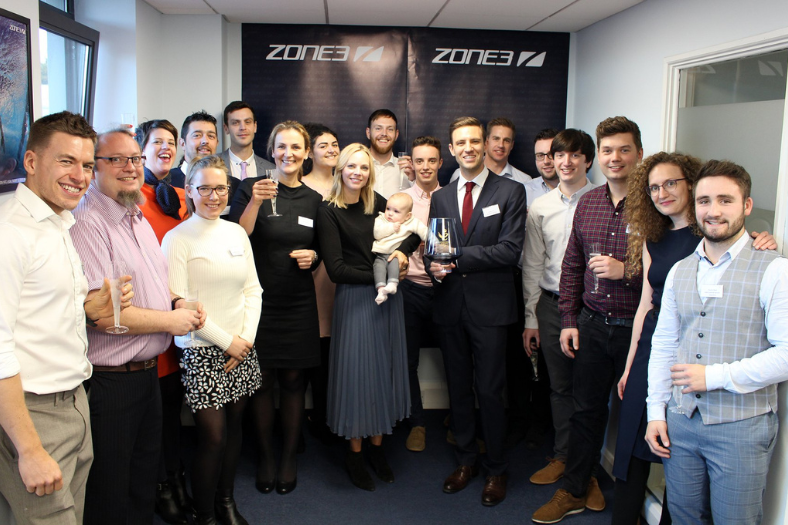 L'équipe ZONE3 de 2018 souriant pour la photo ; au centre, le fondateur James Lock tient le Queen's Award for Enterprise.