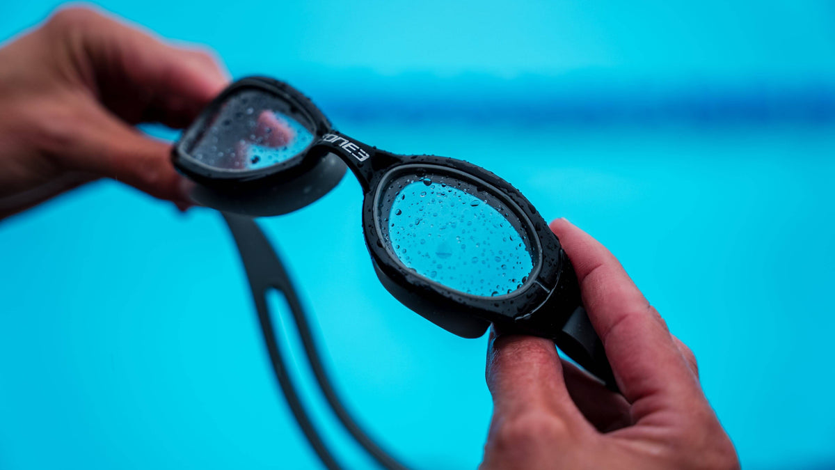 Person holding a pair of Zone3 attack swim goggles