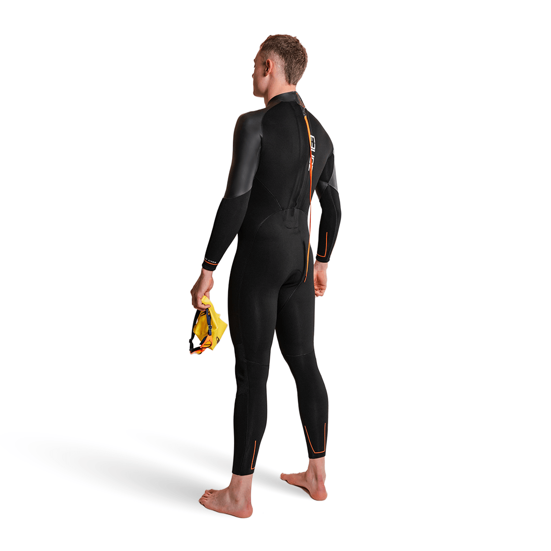 Combinaison néoprène Active-Flex portée par un nageur debout, bonnet de bain à la main, mettant en valeur son design épuré.