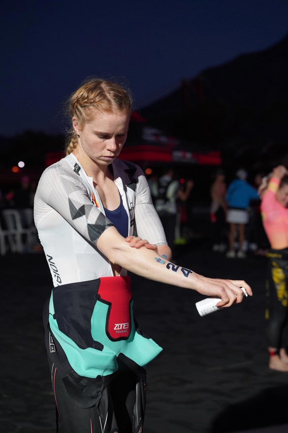 Personne appliquant un strap sur son poignet lors d'un événement, sur fond sombre