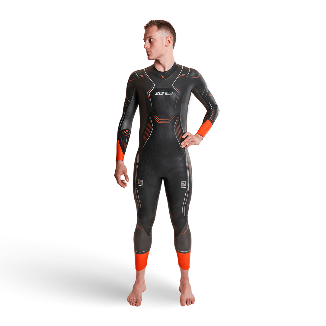 Vue de face d'un homme portant la combinaison néoprène Zone3 Vanquish-X avec touches d'orange sur fond blanc. 