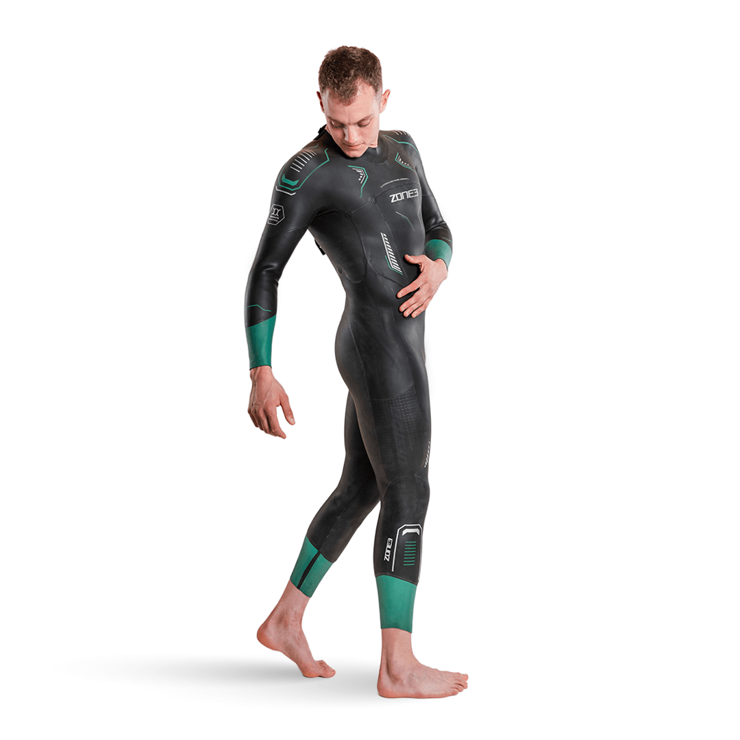 Vue latérale d'un homme en combinaison néoprène Vision noire avec manchettes vert d'eau aux bras et aux mollets